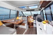 Jeanneau Merry Fisher 1095 - wheelhouse interior with port side saloon seating, starboard side galley and forward pilot + co-pilot seats Jeanneau Merry Fisher 1095